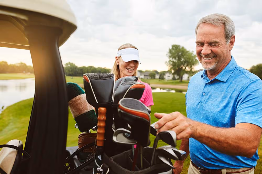 Active mature couple golfing together enjoying an active lifestyle made possible by better hearing