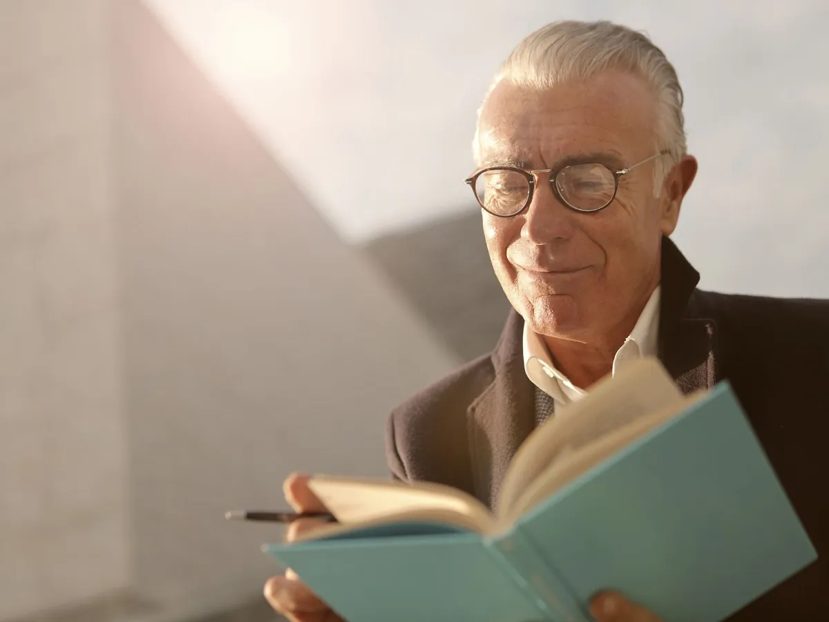 Older man in glasses reading a book
