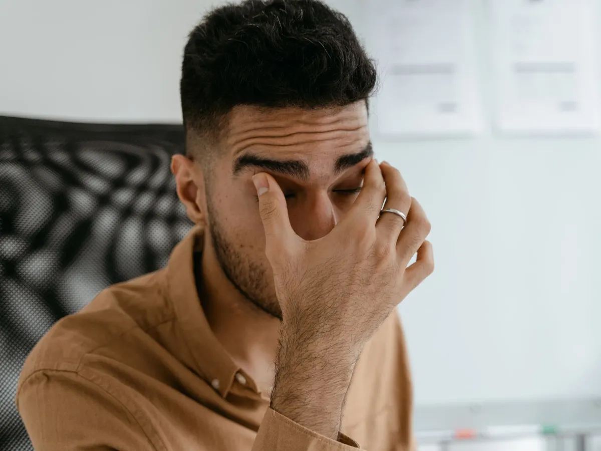 Man holding his irritated eye