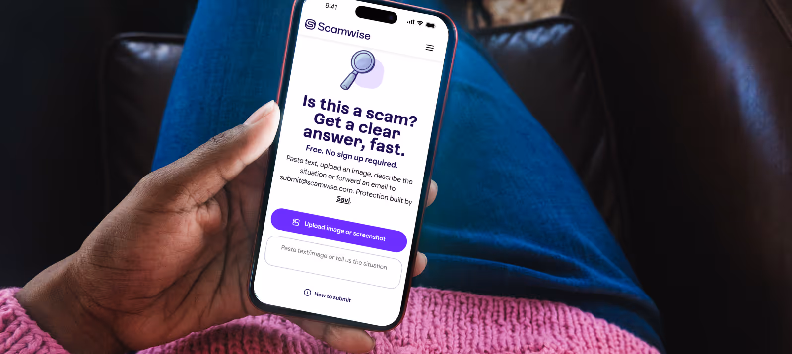 Hand holding a smartphone showing Scamwise website with text asking if something is a scam and offering a fast, free answer with an option to upload an image or paste text.