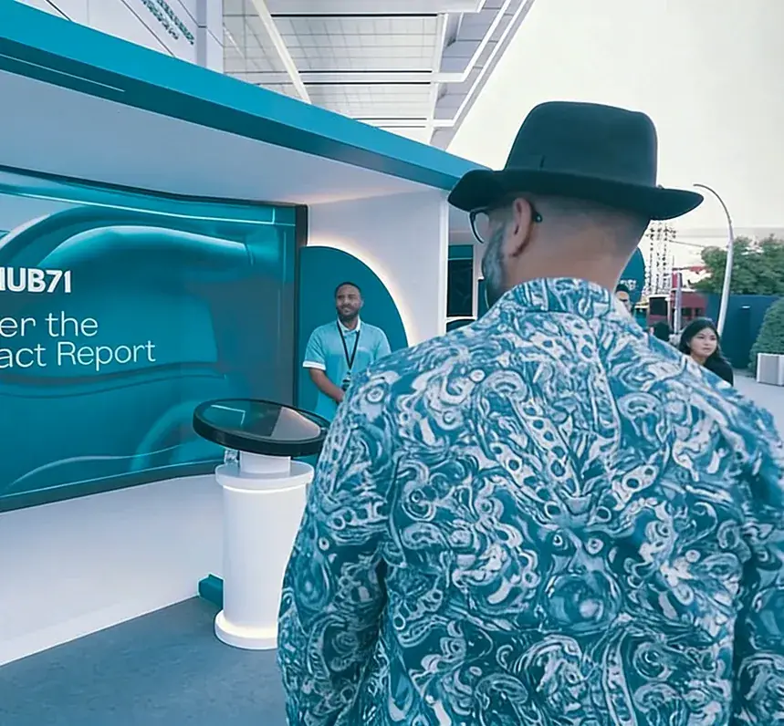 Presenter using the Hub71 touch-and-throw impact report application
