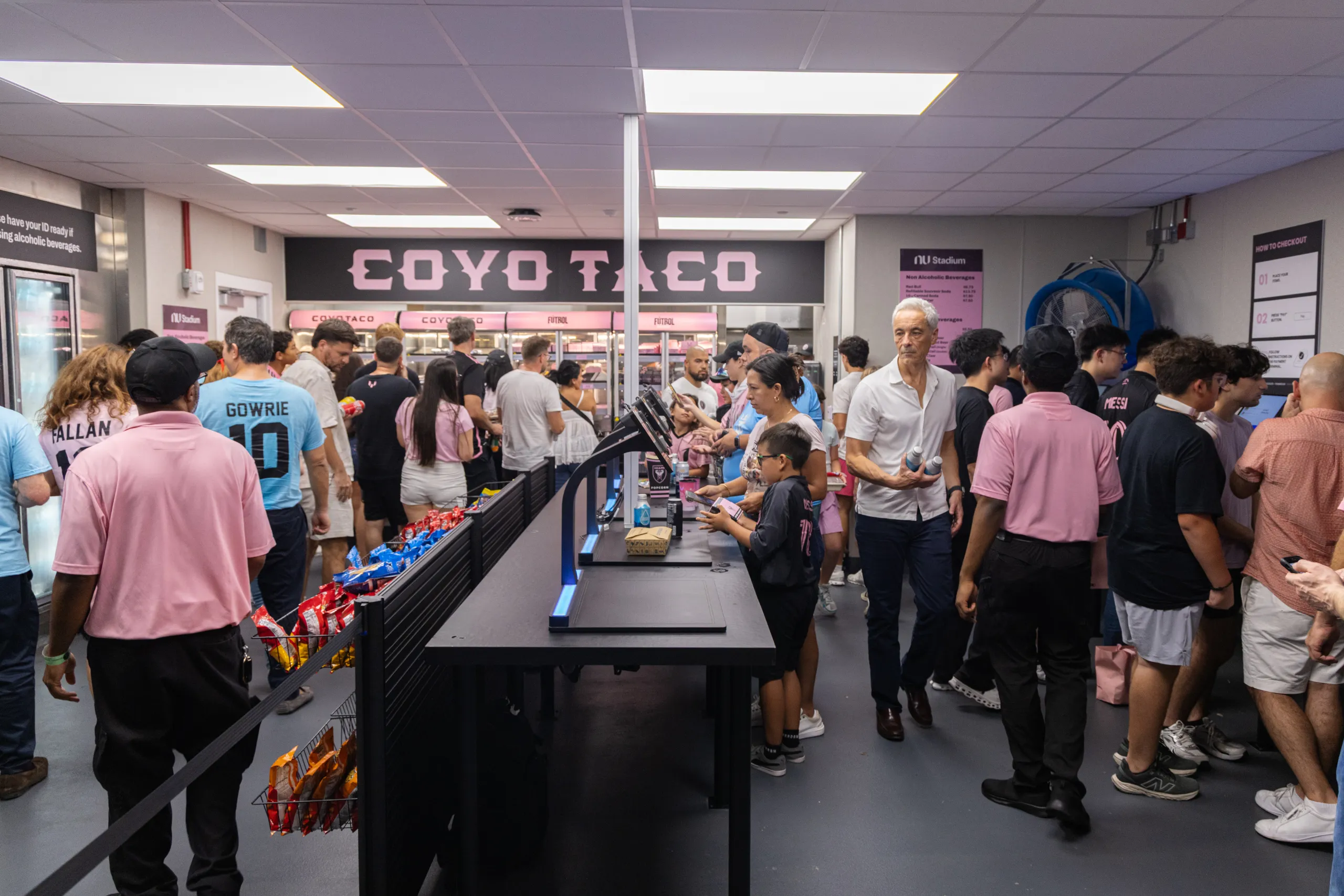 Stadionbesucher in einem Selbstbedienungsmarkt kaufen Speisen und Getränke an den VisioLab Self-Checkout Systemen