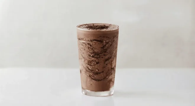 Wingstop Oreo & Chocolate Milkshake, Oreo and chocolate milkshake with cookie pieces in a tall clear glass, nutrition and calories