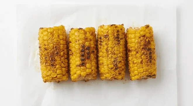 Wingstop Style Corn on the Cob, grilled corn on the cob pieces with seasoning on white paper, nutrition and calories