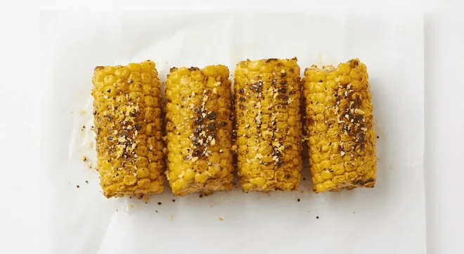 Wingstop Lemon Pepper Corn on the Cob, corn on the cob pieces seasoned with lemon pepper on white paper, nutrition and calories