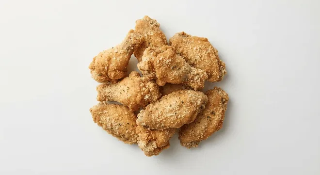 Wingstop Garlic Parmesan Wings, chicken wings tossed in garlic parmesan seasoning on a white background, nutrition and calories