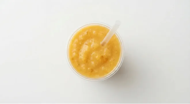 McDonald's Mango & Pineapple Smoothie (Large), mango and pineapple smoothie in a clear cup with a straw, seen from above, nutrition and calories
