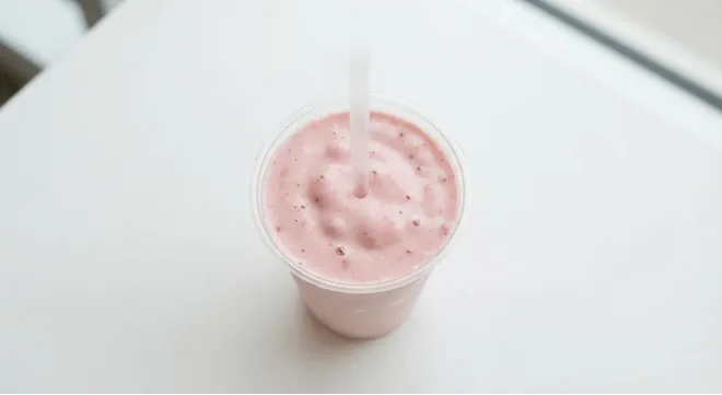 McDonald's Strawberry Milkshake (Large), strawberry milkshake in a clear cup with a straw, nutrition and calories