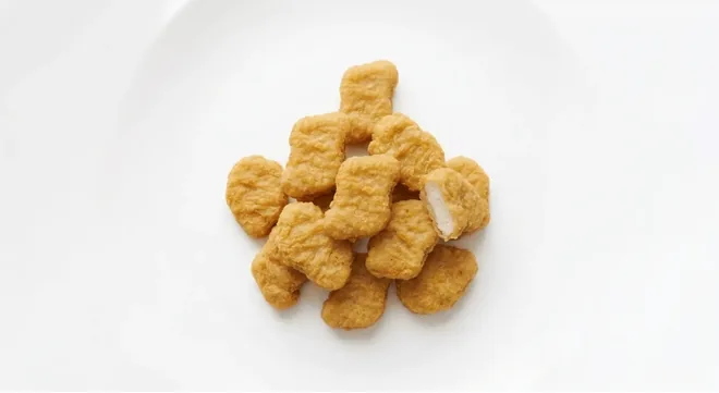 McDonald's Chicken McNuggets (9 pieces), pile of golden chicken nuggets on a white plate, nutrition and calories