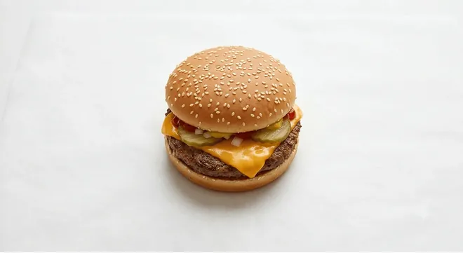 McDonald's Cheeseburger, beef burger with cheese, onion and pickles in a sesame bun, nutrition and calories