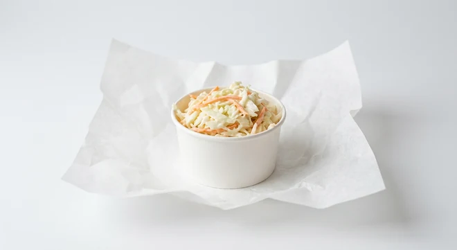 Slim Chickens Coleslaw, creamy shredded cabbage and carrot coleslaw in a white pot on white paper, nutrition and calories