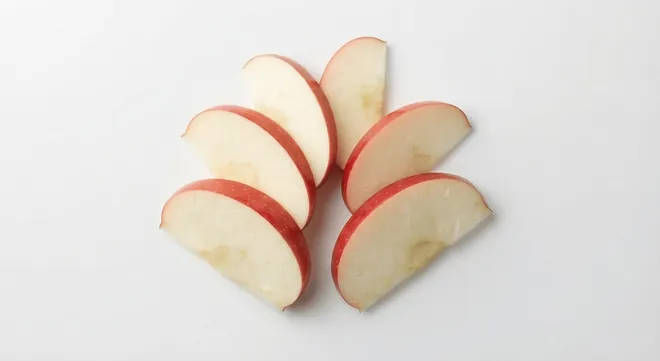 McDonald's US Apple Slices, thin unpeeled apple slices with red skin, arranged in a fan