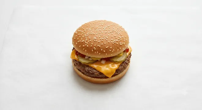 McDonald's US Cheeseburger, a beef patty with melted cheese, pickles and onions in a soft bun