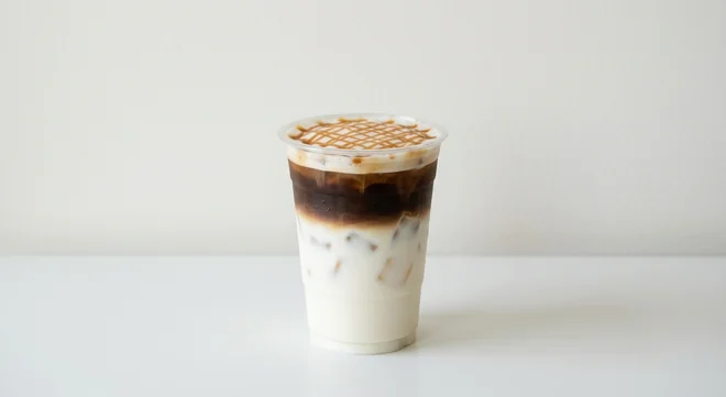 Costa Iced Caramel Macchiato (Small, Oat Milk), layered milk, espresso and caramel drizzle over ice in a clear cup, nutrition and calories