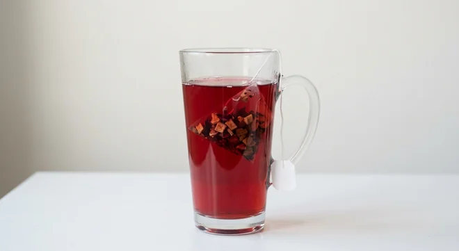 Costa Spiced Apple with Vitamin B6 (Medium), ruby-red spiced apple fruit infusion with a pyramid tea bag in a tall glass mug, nutrition and calories