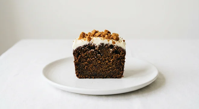 Costa Gingernut Loaf Cake, slice of ginger loaf cake with cream cheese frosting and biscuit crumble on a white plate, nutrition and calories