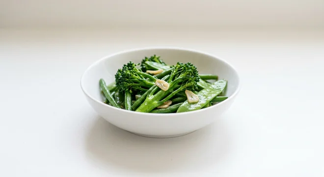 Wagamama Wok-Fried Greens, tenderstem broccoli, fine beans and mangetout in garlic soy sauce in a white bowl, nutrition and calories