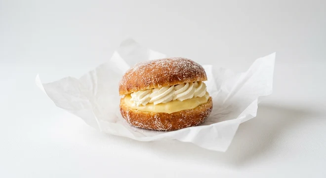 Greggs Vanilla Custard Cream Doughnut, sugared doughnut filled with vanilla custard and cream on white paper, nutrition and calories
