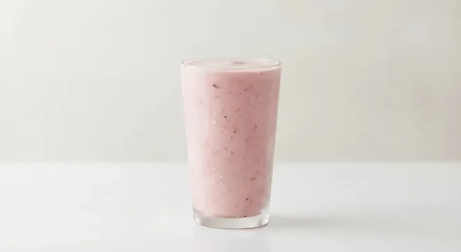 Caffè Nero Strawberry Milkshake, pink strawberry milkshake in a tall clear glass, nutrition and calories