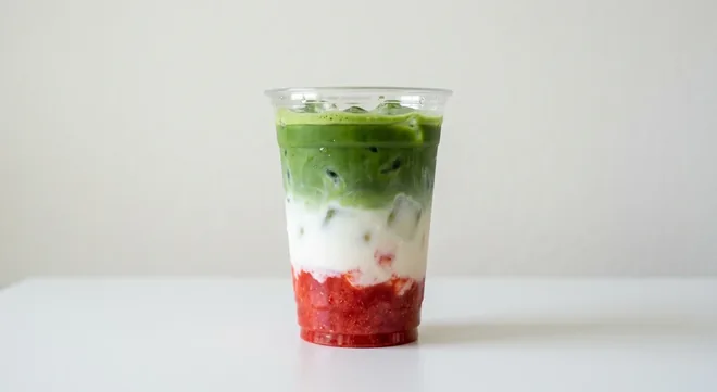 Caffè Nero Strawberry & Vanilla Iced Matcha (Coconut Milk), layered strawberry, milk and green matcha over ice in a clear cup, nutrition and calories
