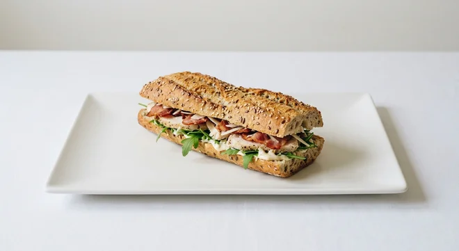 Pret A Manger Chicken Caesar & Bacon Half Baguette, chicken Caesar and bacon half baguette on a white plate, nutrition and calories