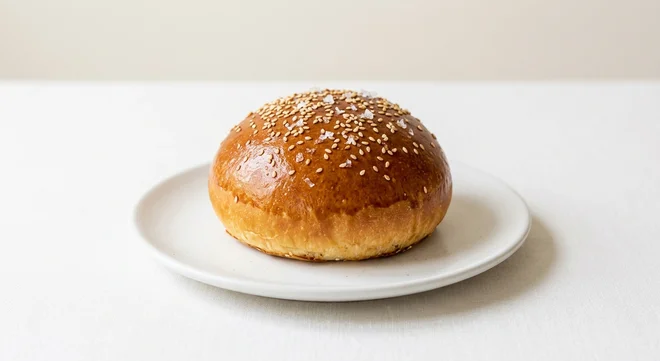 GAIL's Burger Bun, glossy brioche burger bun with sesame seeds on a white plate, nutrition and calories