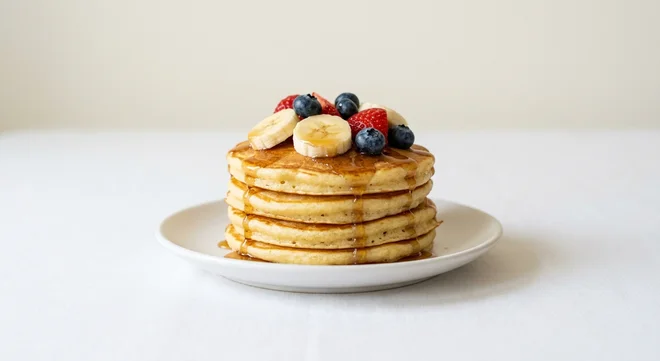 Wetherspoon American-Style Pancakes with Fresh Fruit, four American-style pancakes topped with banana, strawberries, blueberries and maple syrup on a white plate, nutrition and calories