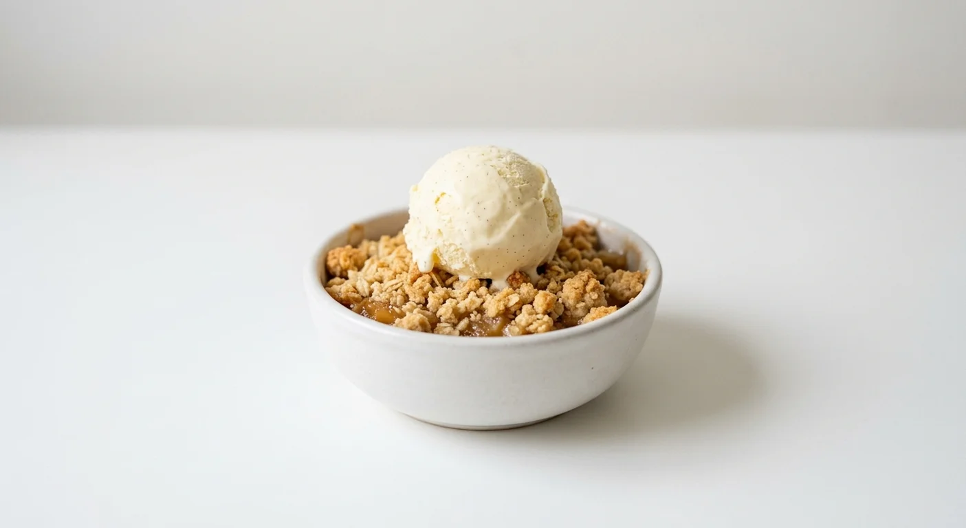 Wetherspoon British Bramley Apple Crumble with Ice Cream, warm Bramley apple crumble with a scoop of vanilla ice cream in a white bowl, nutrition and calories