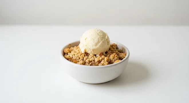 Wetherspoon British Bramley Apple Crumble with Ice Cream, warm Bramley apple crumble with a scoop of vanilla ice cream in a white bowl, nutrition and calories
