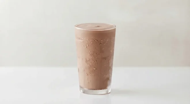 Burger King US Chocolate Shake, a thick chocolate milkshake in a tall clear glass, nutrition and calories