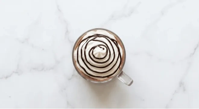 Starbucks US Hot Chocolate (Grande), hot chocolate with a chocolate swirl on top in a glass mug, seen from above, nutrition and calories