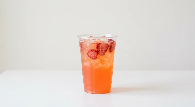 Starbucks US Mango Strawberry Energy Refresher (Grande), coral fruit drink over ice with strawberry slices in a clear cup, nutrition and calories