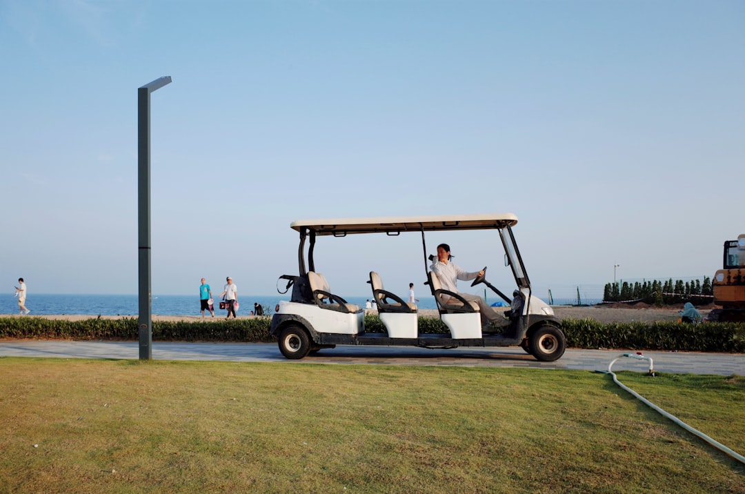A person drives a golf cart along the coast.