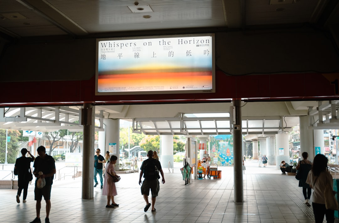 People walking under a large illuminated advertisement