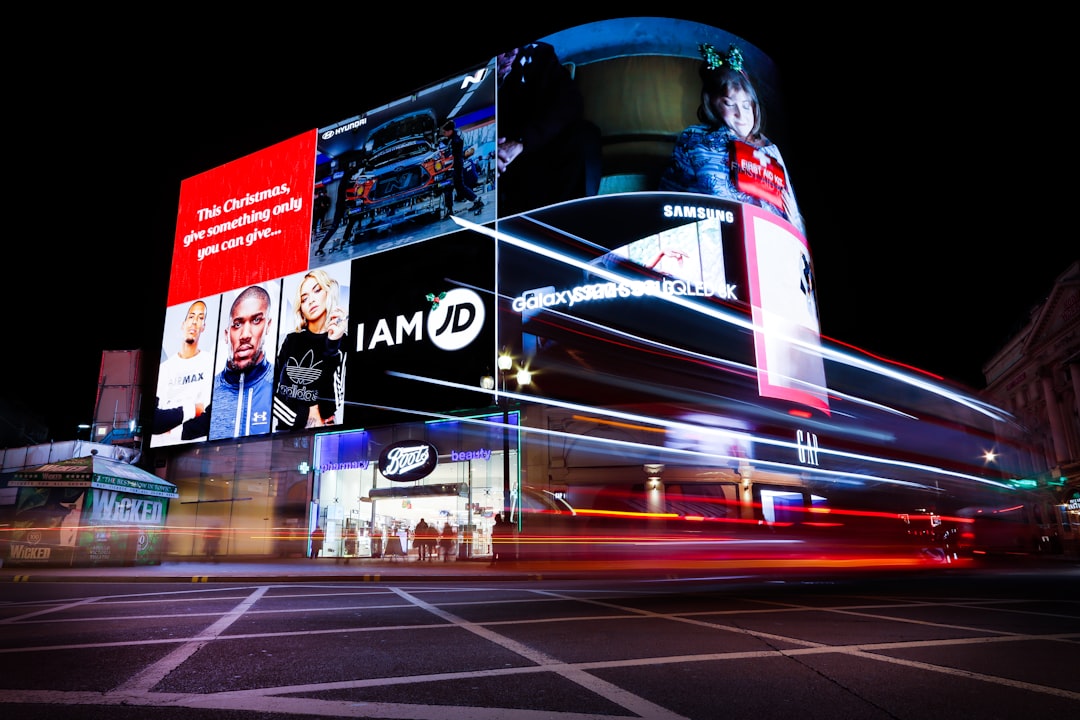 Busy cityscape with illuminated billboards and light trails at night