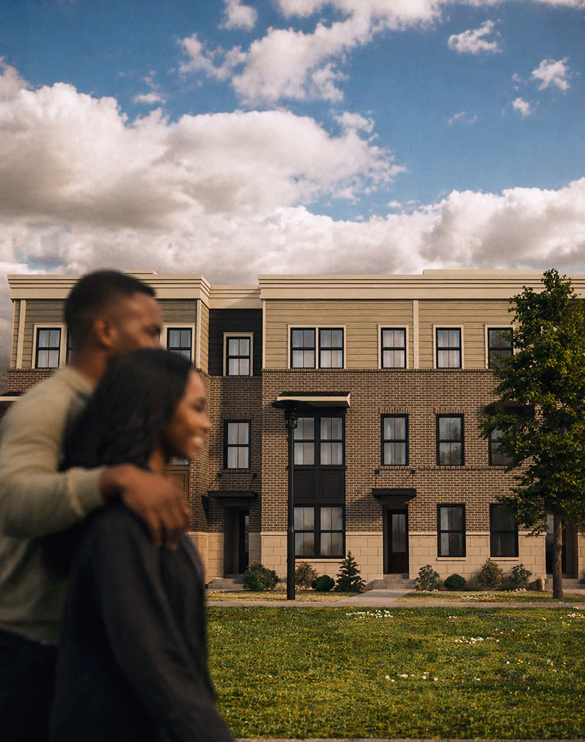 Couple walking arm in arm in front of a modern three-story brick and siding residential building.