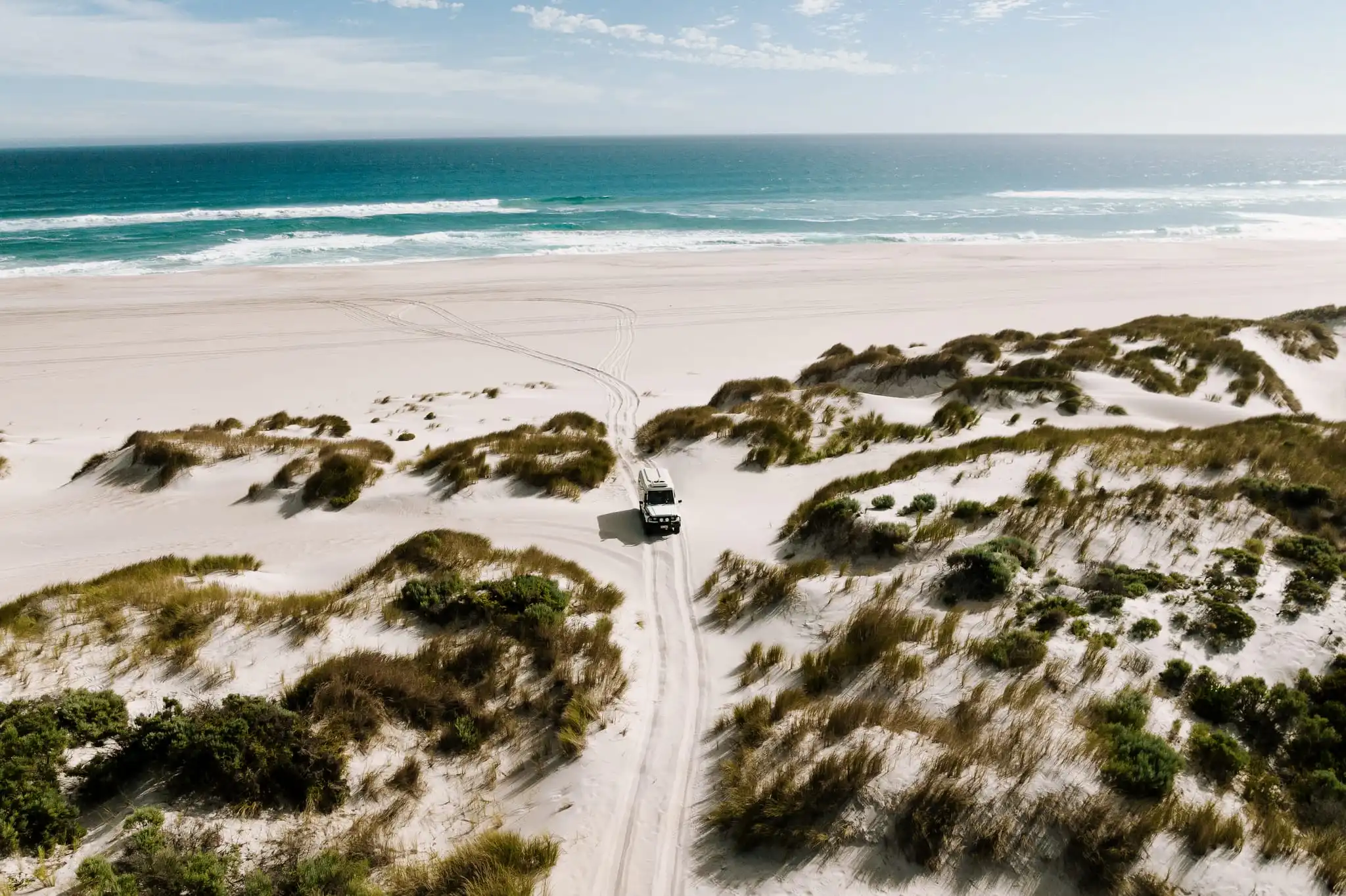Beach scene with 4wd driving on a track