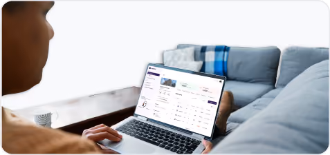 Person using a laptop showing a real estate listing with property details on screen.