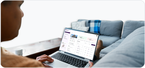 Person using a laptop showing a real estate listing with property details on screen.