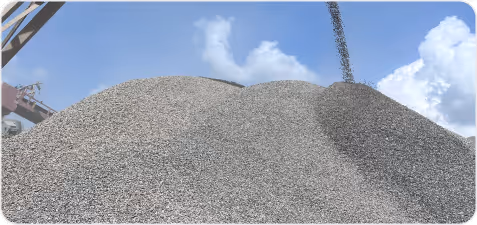 Large piles of gravel or small stones under a partly cloudy sky.