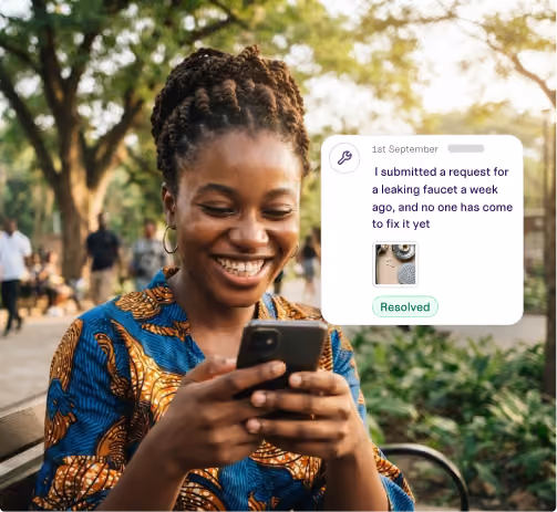 Smiling woman outdoors holding a phone with a message about a resolved leaking faucet request.