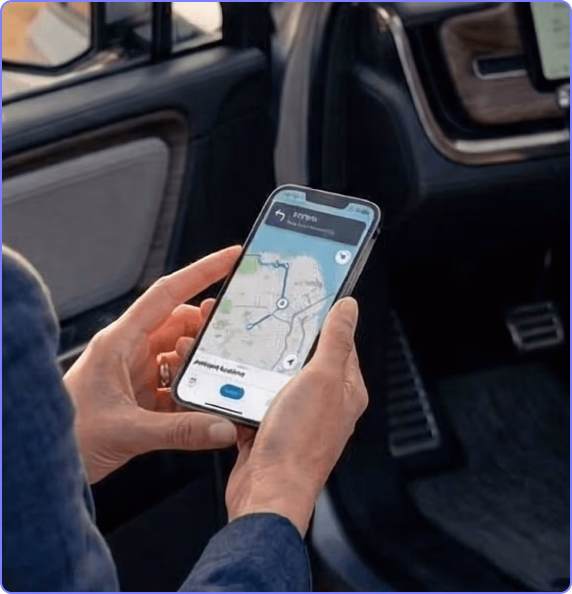Person holding a smartphone displaying a navigation app with a map and route inside a car.