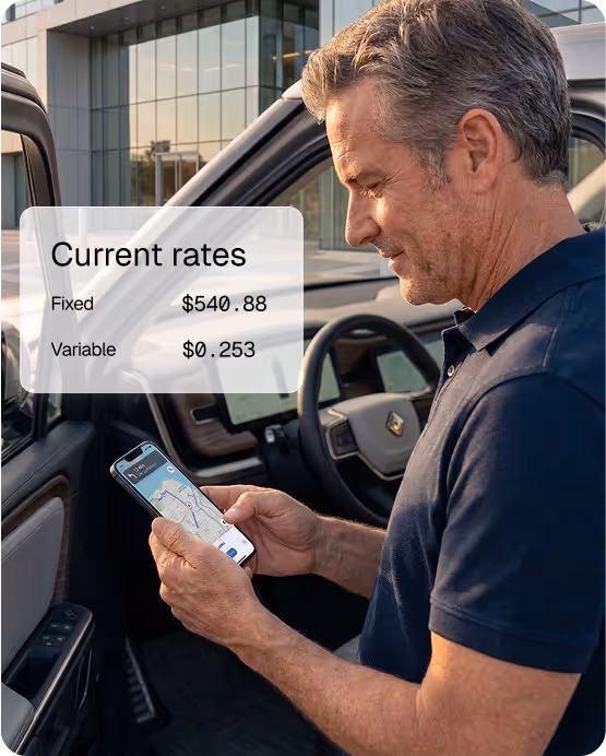 Man standing beside an open car door looking at a smartphone displaying a map, with an overlay showing current rates: Fixed $540.88, Variable $0.253.