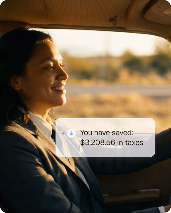 Smiling woman driving a car with text overlay showing tax savings of $3,208.56.