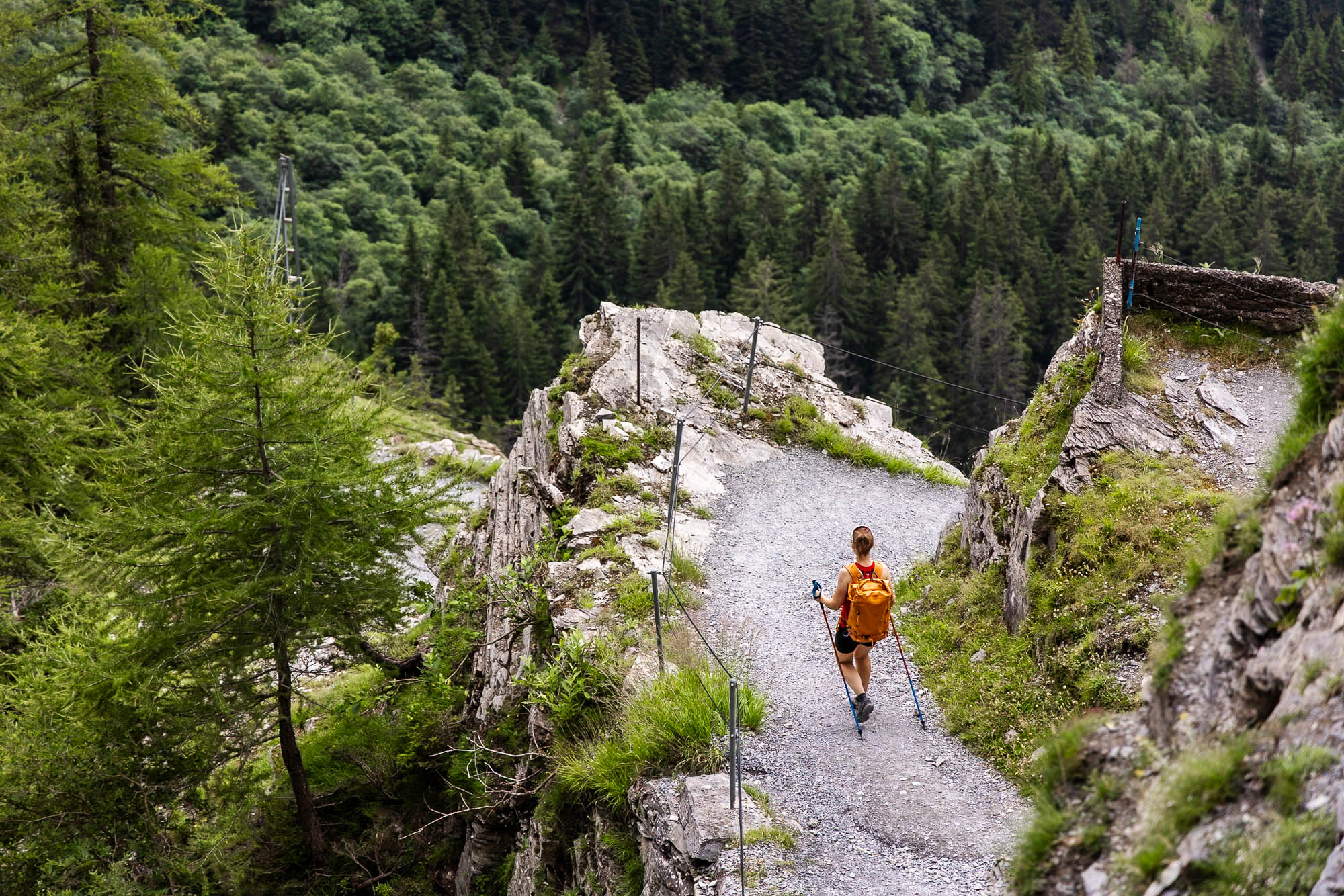 Marina Kraus beim Abstieg von der Gemmi in Leukerbad, Wallis, Schweiz. Steiniger Weg, am Rand ein Seilgeländer.