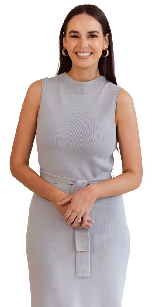 Shaina standing in a grey dress.