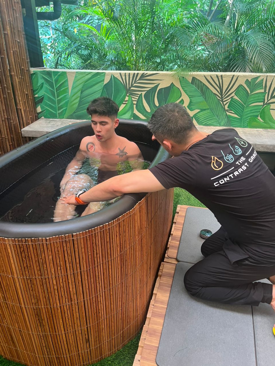 Man getting guidance on how to do a cold plunge