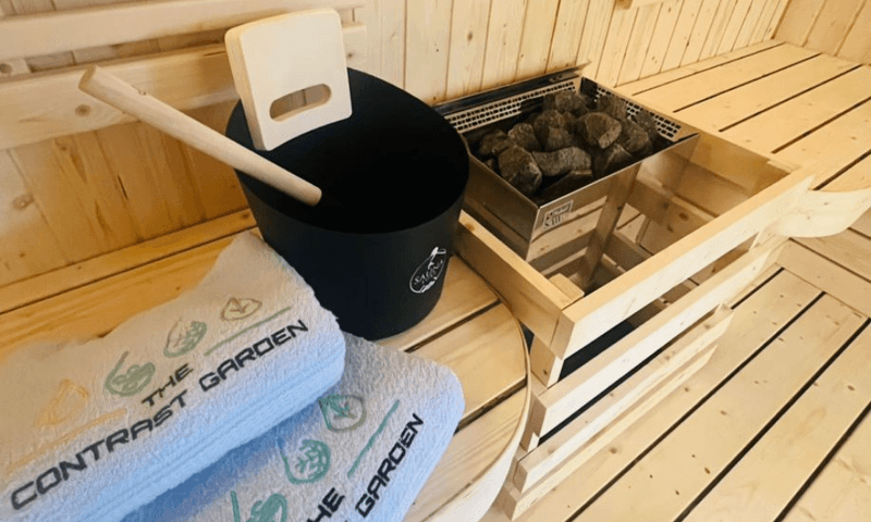 Sauna essentials at The Contrast Garden: ladle, bucket, and hot stones ready for a session