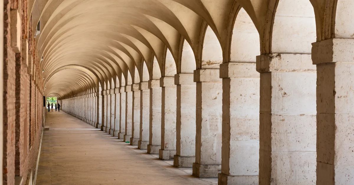 Arcade walkway with repeating arches in warm light