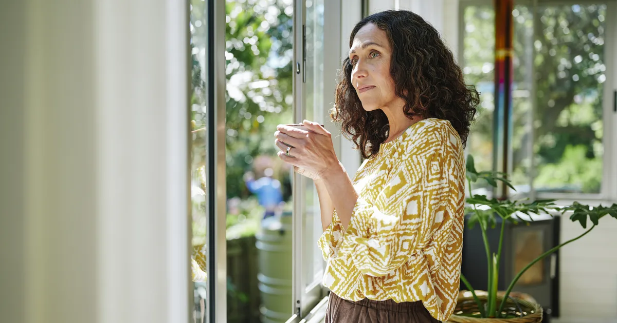 Woman at a window in soft garden light